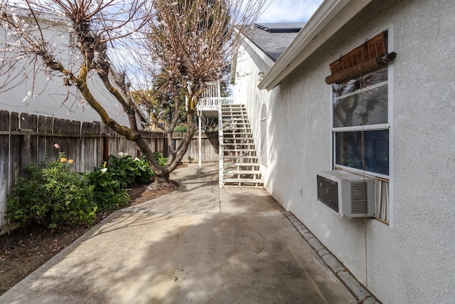 view of patio with fence, stairway, and cooling unit