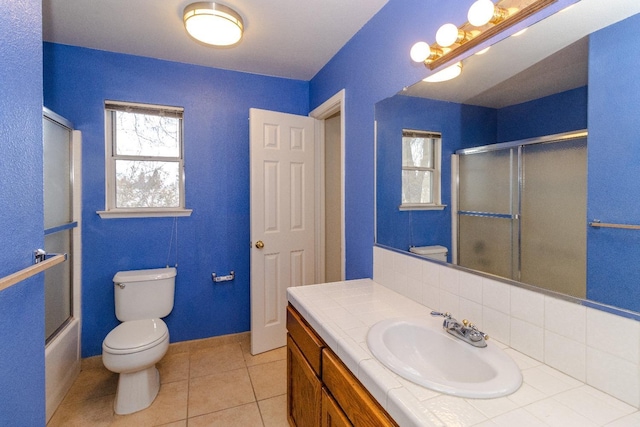 full bathroom featuring toilet, vanity, baseboards, backsplash, and tile patterned floors