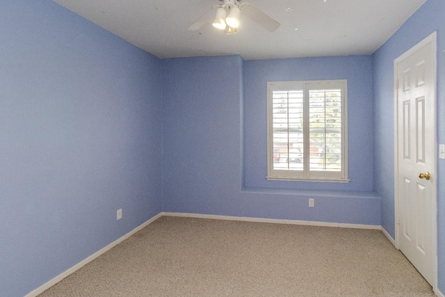 spare room with light carpet, ceiling fan, and baseboards