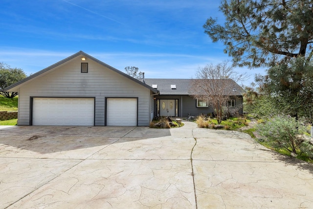 ranch-style house with an attached garage and concrete driveway