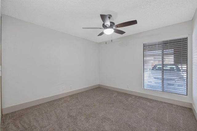 empty room featuring a ceiling fan, carpet, a textured ceiling, and baseboards