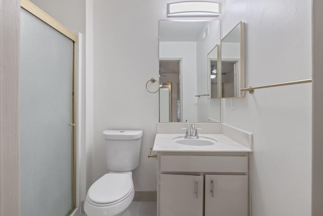 full bath with a stall shower, baseboards, toilet, tile patterned floors, and vanity