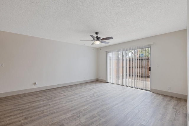 unfurnished room with ceiling fan, a textured ceiling, baseboards, and wood finished floors