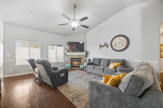 living room with baseboards, lofted ceiling, ceiling fan, dark wood-style flooring, and a fireplace