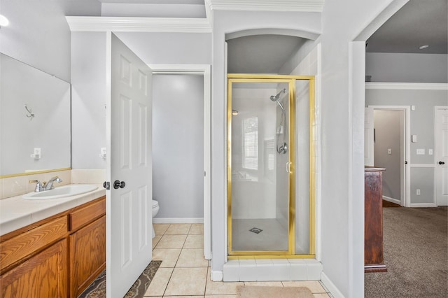 bathroom featuring toilet, vanity, baseboards, tile patterned floors, and a stall shower