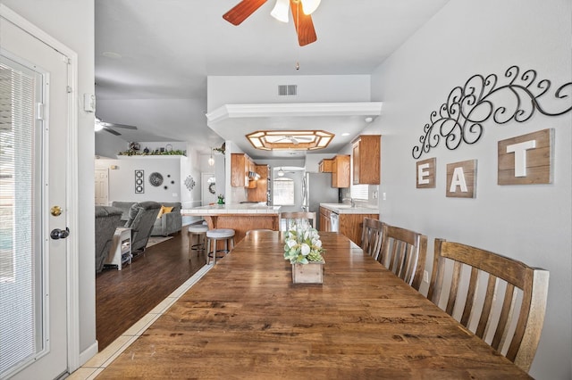 tiled dining space with ceiling fan and visible vents