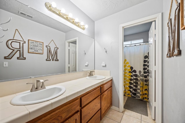 bathroom featuring double vanity, tile patterned flooring, a sink, and visible vents