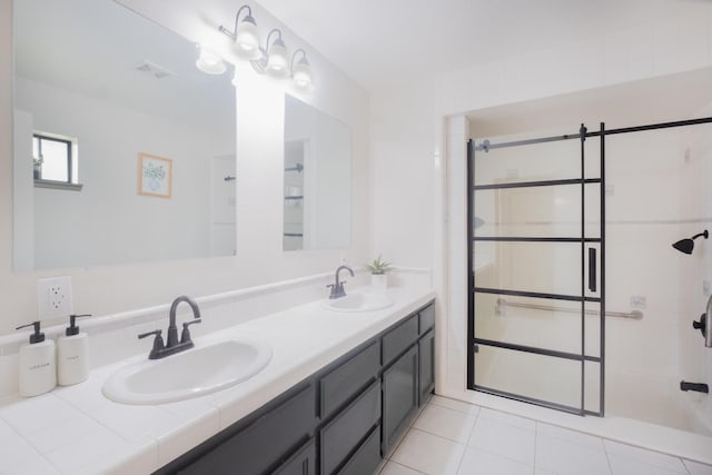 full bath with double vanity, a stall shower, visible vents, and a sink