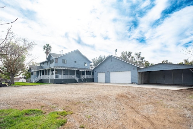 view of front of property featuring a carport, covered porch, driveway, and a garage