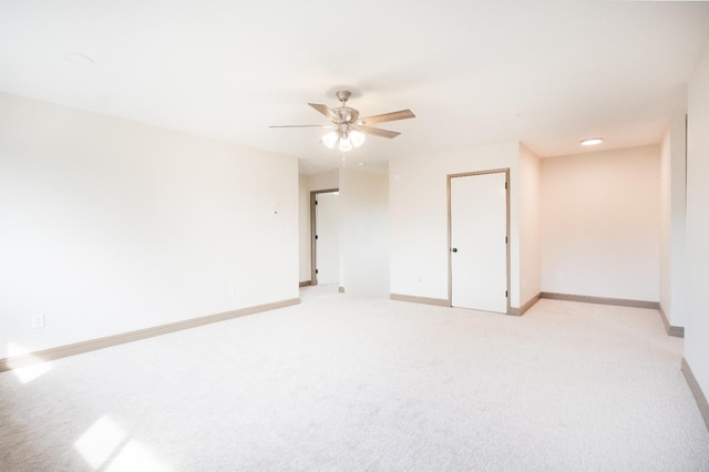 empty room with light carpet, ceiling fan, and baseboards