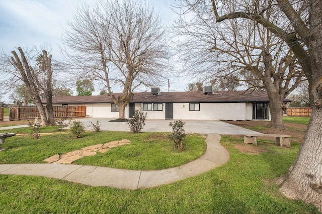 ranch-style house featuring driveway, a patio area, fence, and a front lawn