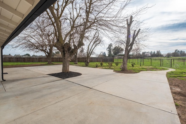 view of patio / terrace with concrete driveway and fence