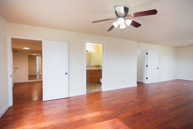 spare room featuring ceiling fan, baseboards, and wood finished floors