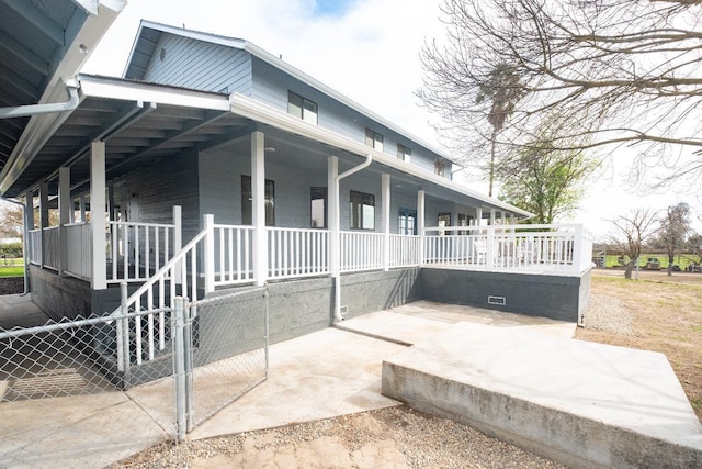 view of home's exterior with fence and a porch