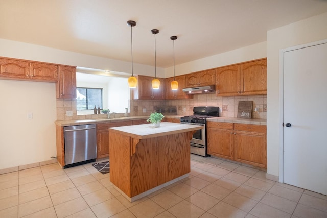 kitchen featuring a kitchen island, appliances with stainless steel finishes, under cabinet range hood, backsplash, and light tile patterned flooring