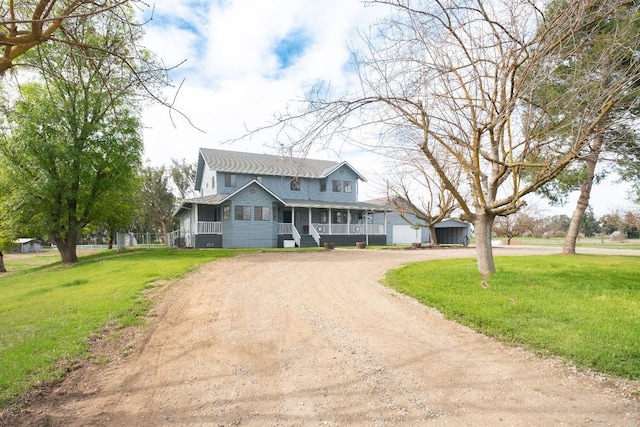 view of front of house featuring a porch, a front lawn, and dirt driveway