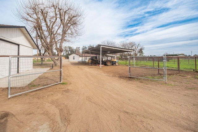 view of road featuring a gate, a rural view, driveway, and a gated entry