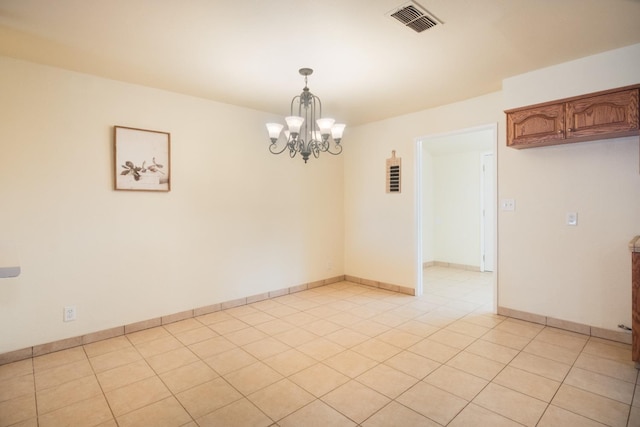 unfurnished room featuring an inviting chandelier, baseboards, light tile patterned floors, and visible vents