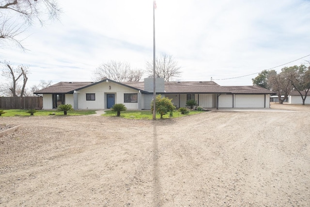 single story home with a garage, driveway, and fence