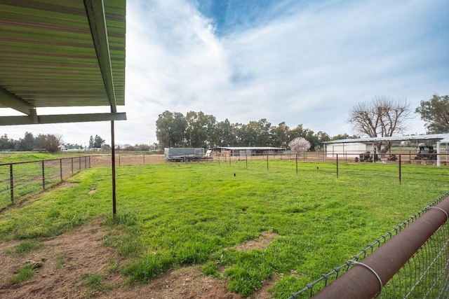 view of yard with fence and a rural view