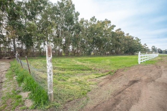 view of yard featuring fence and a rural view