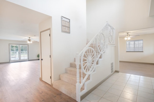 stairway with ceiling fan, wood finished floors, visible vents, baseboards, and french doors