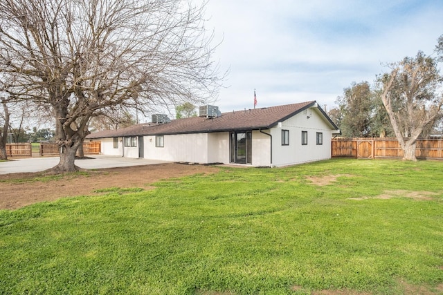 back of property with a patio area, a lawn, a fenced backyard, and central AC unit