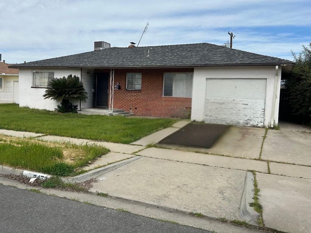 ranch-style house featuring driveway, a garage, roof with shingles, a front lawn, and brick siding