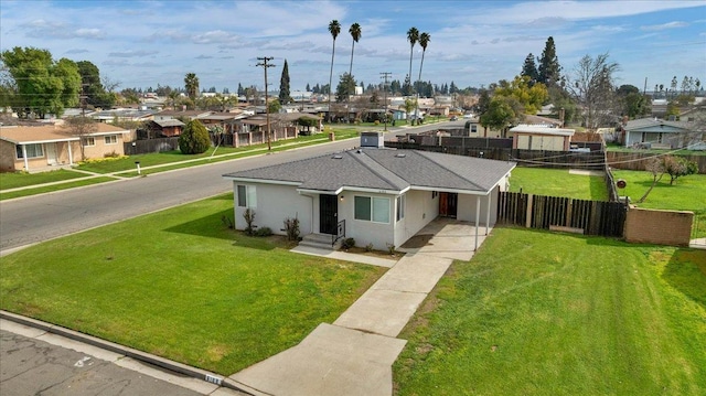 ranch-style home with a front yard, a residential view, fence, and stucco siding