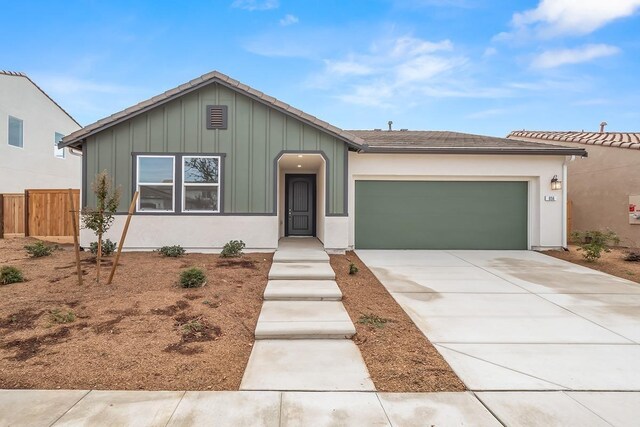 ranch-style house featuring a garage, fence, board and batten siding, and concrete driveway