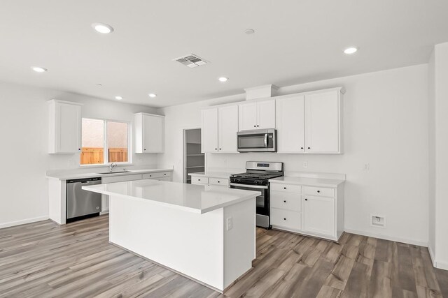 kitchen featuring visible vents, a sink, light countertops, stainless steel appliances, and light wood-style flooring