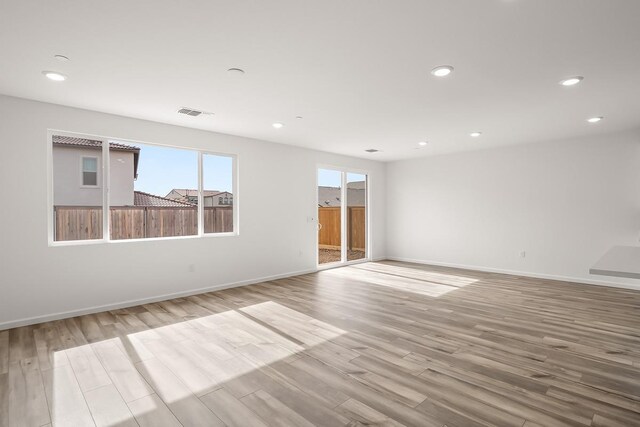 empty room featuring recessed lighting, light wood-style floors, and baseboards