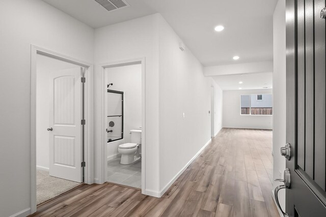 hall featuring visible vents, recessed lighting, baseboards, and wood finished floors