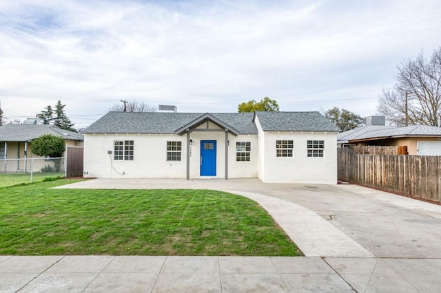 single story home with a front lawn, a shingled roof, fence, and stucco siding