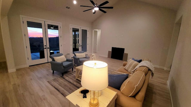 living room with visible vents, light wood-style flooring, french doors, and baseboards