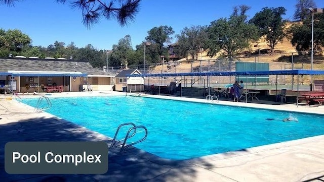 community pool featuring a patio and fence