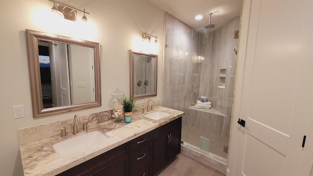 bathroom with a sink, double vanity, and a shower stall