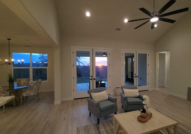 living area with visible vents, high vaulted ceiling, french doors, light wood finished floors, and baseboards