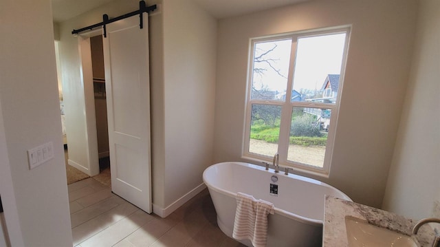 full bath featuring a freestanding tub, baseboards, and a sink