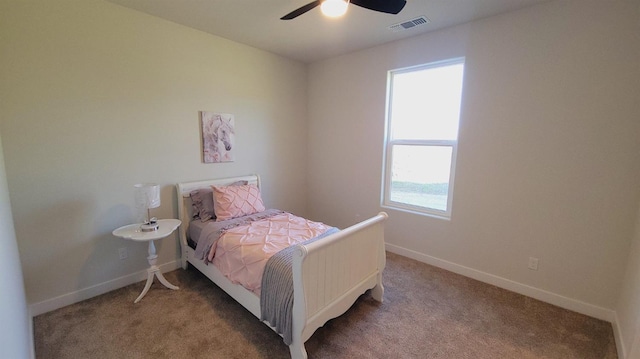 carpeted bedroom with visible vents, baseboards, and a ceiling fan