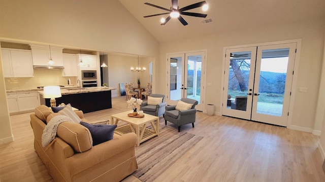 living room with ceiling fan with notable chandelier, light wood-style floors, french doors, and visible vents