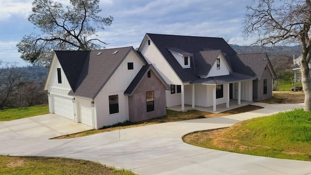 modern farmhouse style home with board and batten siding, a shingled roof, a porch, driveway, and an attached garage