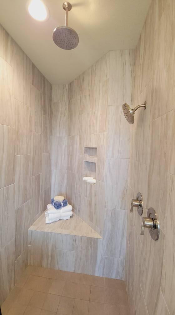 bathroom featuring a tile shower and tile patterned flooring