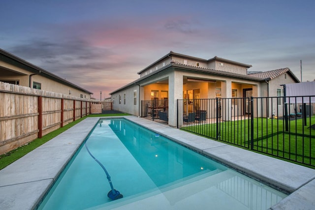 view of swimming pool with a fenced in pool, a patio area, a fenced backyard, and a lawn