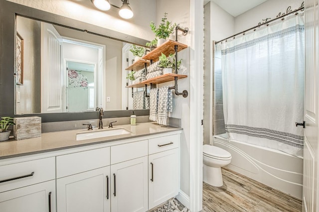 bathroom featuring shower / bath combo with shower curtain, vanity, toilet, and wood finished floors