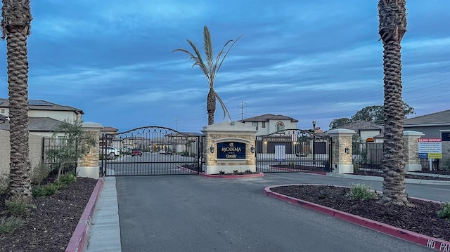 view of road with a gate, curbs, and a gated entry