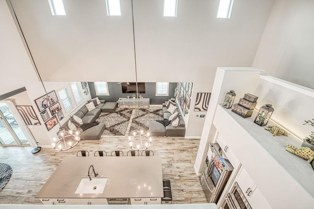 living area with a high ceiling, baseboards, a fireplace, and wood finished floors