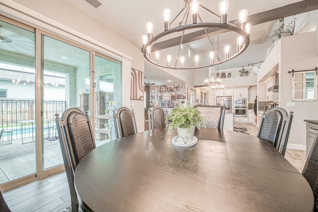 dining room featuring a chandelier, wood finished floors, and baseboards