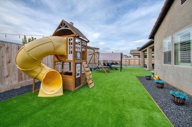 view of playground with a fenced backyard and a lawn