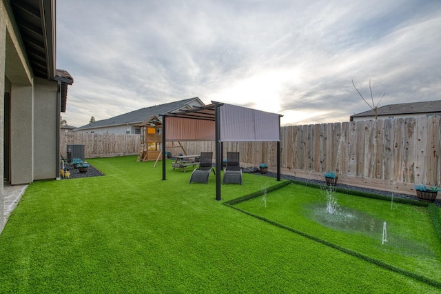 view of yard with a fenced backyard, a playground, and cooling unit